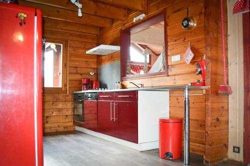 a kitchen with wooden walls and a red refrigerator at Chalet familial à Vagney + Jardin et Terrain de Bowling in Vagney