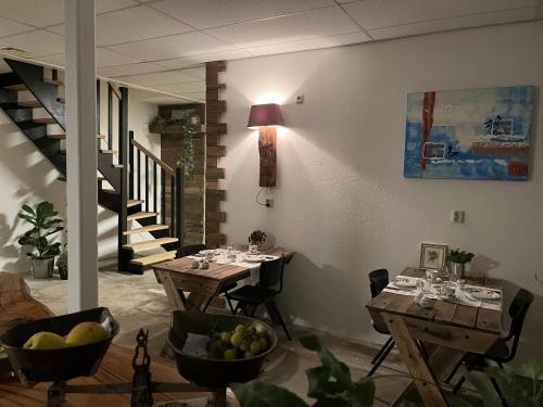 a dining room with two tables and a staircase at Thorn BenB in Thorn