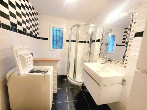 a white bathroom with a sink and a shower at Appartement Sophie à Vals les bains in Vals-les-Bains