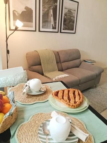 a living room with a table with a pie on it at Lake Como PORTO VECCHIO in Domaso