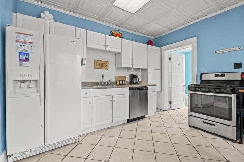 a kitchen with white appliances and blue walls at Southern Breezes Nor' Wester - close to beach! in Cape Charles
