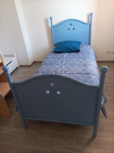 - un lit avec un cadre bleu dans l'établissement Chez Sabine la Campagne HAUT, à Narbonne