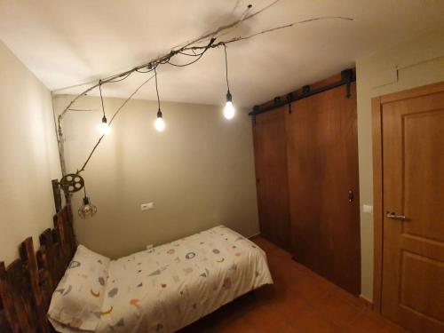 a bedroom with a bed with lights hanging from the ceiling at Paraíso Desconocido 4 La Leyenda del Curavacas in Alba de los Cardaños