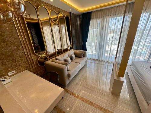 a living room with a couch and a bed in a room at Bellevue Lagoon Phuket in Laguna Phuket