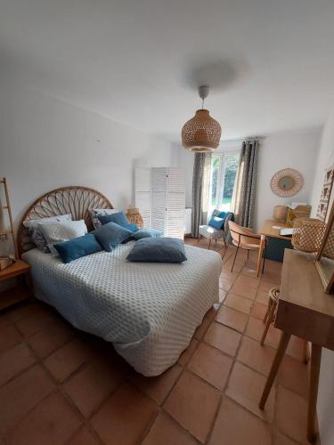 une chambre avec un lit avec des oreillers bleus dessus dans l'établissement MAS Sun villa famille en campagne, à Althen-des-Paluds