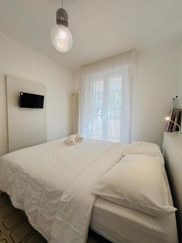 a bedroom with a large white bed and a window at Angiolieri Flexrent - Immobiliare Abissinia in Riccione