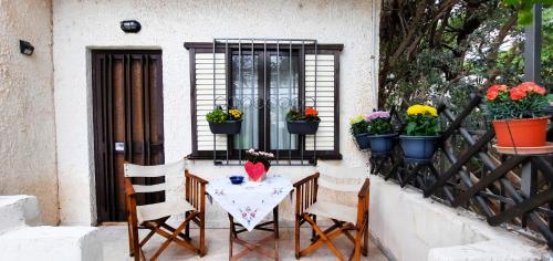 una mesa con sillas y flores en el balcón en "Vintage style" mini apartment, en Áyios Spirídhon