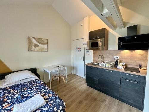 une chambre avec un lit et une petite cuisine dans l'établissement Charmant Studio Bd Lafayette tout équipé 16, à Clermont-Ferrand