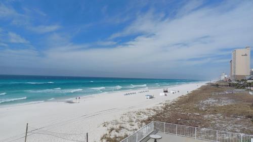 a beach with white sand and the ocean at COUPLES GETAWAY, HONEYMOON SWEET, Perfectly Cozy Beach Front Condo with kitchen, pool, free parking,CHECK-IN AT DOOR in Panama City Beach