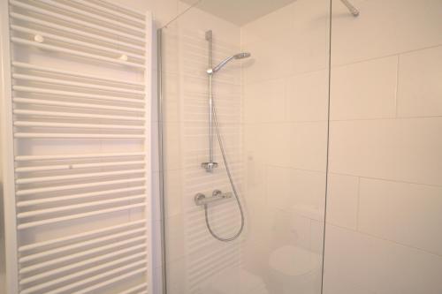 a bathroom with a shower with a glass door at Apparthotel De Wielingen in Westende Bad