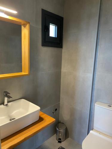 a bathroom with a sink and a toilet and a mirror at kipaki-trachila Mani in Trakhíla