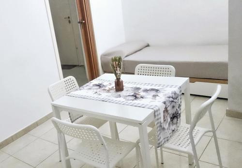 a white table with chairs and a bed in a room at Nonna Rosa House - Cozy Apartment - Molfetta in Molfetta