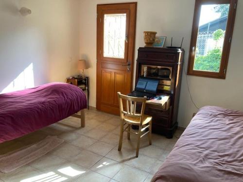 une chambre avec un lit et un bureau avec un ordinateur portable dans l'établissement bastidon, 5 people near beach, sea view, quiet, au Lavandou