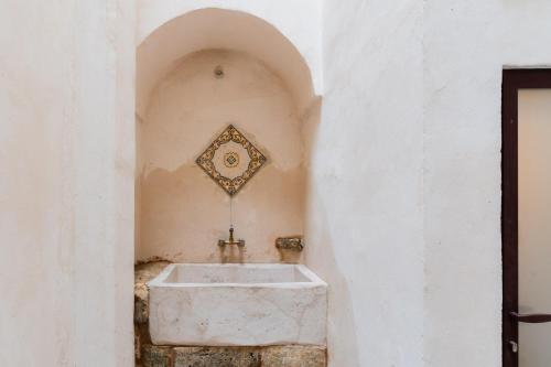 un bagno con lavandino su una parete bianca di Dimora Tizzi - Boutique Apartment - By Just Houses SRL ad Alessano