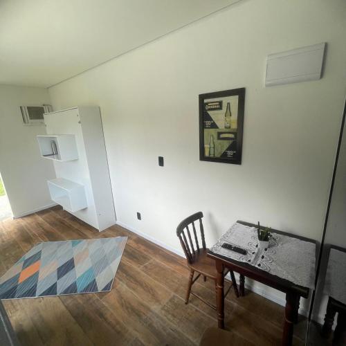 a room with a table and a chair and a small table and a table at Solaris do Una in São Sebastião