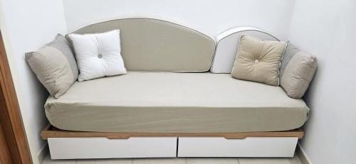 a couch with two pillows on top of it at Nonna Rosa House - Cozy Apartment - Molfetta in Molfetta