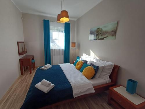 a bedroom with a bed with blue and white sheets and pillows at Apartamenty Vesuvio in Dźwirzyno