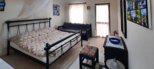 Un dormitorio con una cama y una mesa y dos ventanas. en "Vintage style" mini apartment, en Áyios Spirídhon