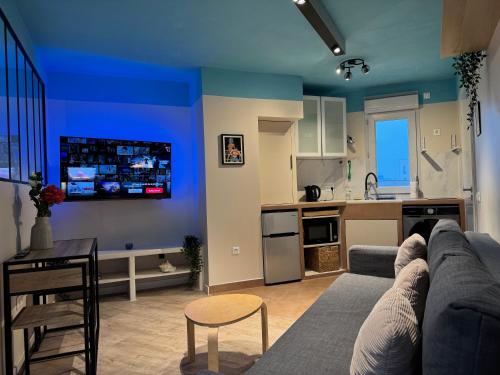 un salon avec un canapé et une cuisine dans l'établissement À deux pas du métro parisien, à Romainville