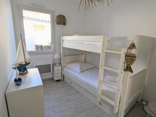 - une chambre avec des lits superposés, un bureau et une fenêtre dans l'établissement Maison neuve de plain-pied avec extérieur, à Pornic