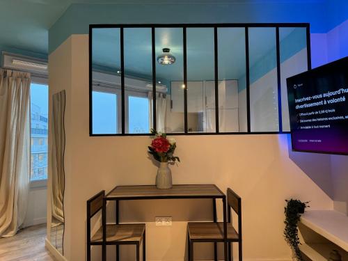 une table avec un vase de fleurs dessus dans l'établissement À deux pas du métro parisien, à Romainville