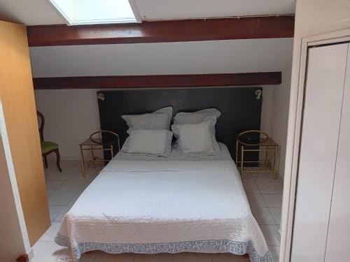 une chambre avec un lit avec des draps blancs et des oreillers dans l'établissement Le Mas de la Mer, aux Lecques