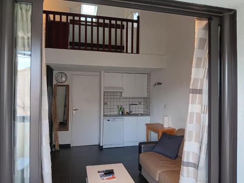 un salon avec un canapé et une cuisine dans l'établissement Le Mas de la Mer, aux Lecques