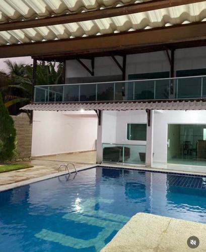 a swimming pool in front of a house at Wcasadepraia in Maragogi