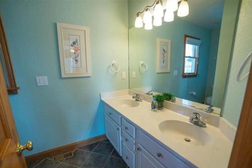 Un baño con dos lavabos y un espejo grande. en Endless Summer Nights, en Waves