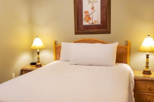 a bedroom with a white bed with two lamps at Waters Edge 314 in Fort Walton Beach