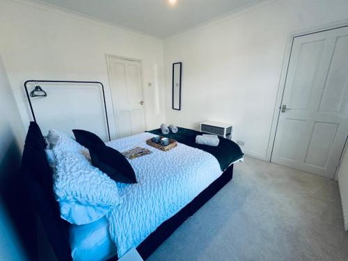 a bedroom with a large bed with blue pillows at Cumberland House-2 Bedrooms - Sleeps 4 in Workington