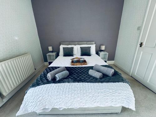 a bedroom with a large bed with blue pillows at Cumberland House-2 Bedrooms - Sleeps 4 in Workington