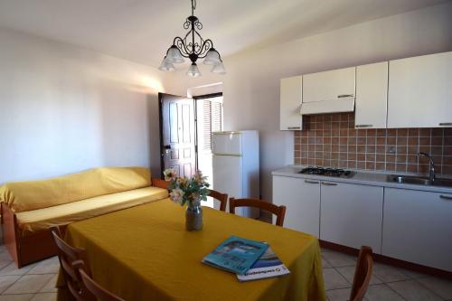 a kitchen and a table with a yellow table cloth at Residenza Agnese Sardegna in La Ciaccia