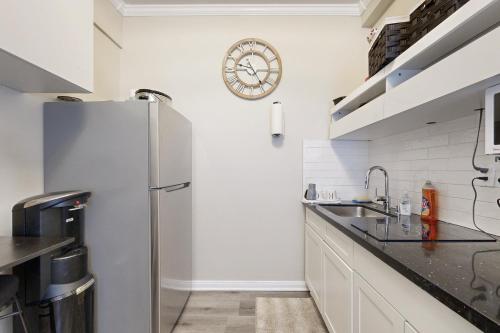 a kitchen with a refrigerator and a clock on the wall at Perris Paradise in Perris