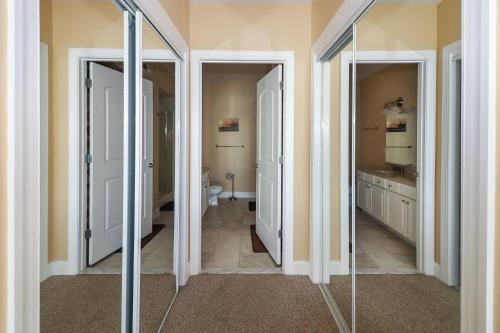 a bathroom with two mirrors and a sink and a toilet at Sunset Bay Villa 116 - Waterfront with shared pool! in Chincoteague