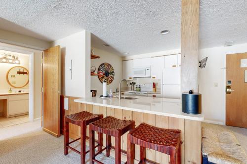 a kitchen with a counter and some stools at Autumn Colors Condo at Rivergreen in Lincoln