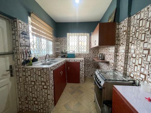 a kitchen with a sink and a stove at Urban Nest in Oshiyie