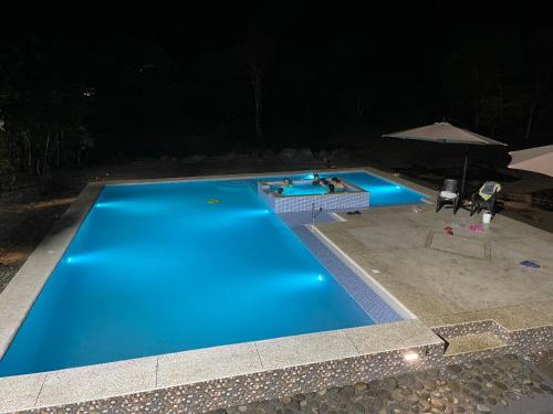 a large blue swimming pool at night at Hostería CASA SAN LUIS in Mindo