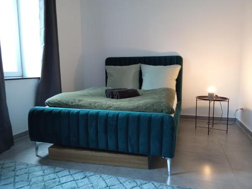 a blue couch sitting in a living room with a lamp at TOPFLAT mit Küche I gratis Parkplatz I zwei Schlafzimmer I zentrumnah in Dortmund