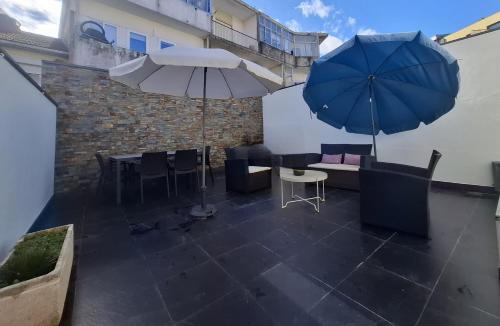 a patio with tables and chairs and an umbrella at Rendez Vous Porto in Porto