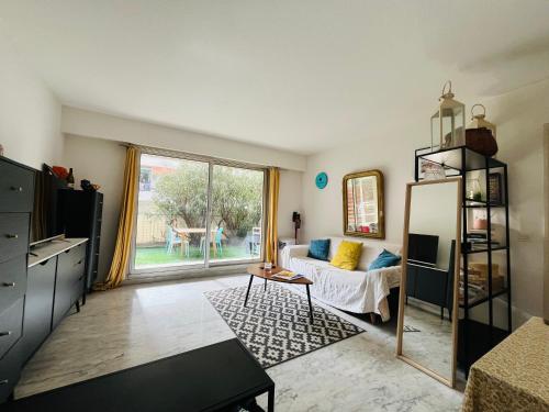 un salon avec un canapé et une table dans l'établissement Appartement avec grande terrasse, à Nice
