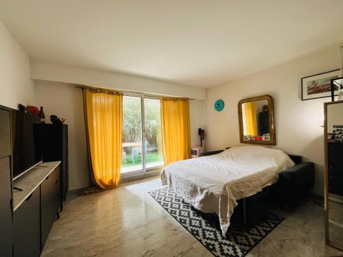 une chambre avec un lit et une grande fenêtre dans l'établissement Appartement avec grande terrasse, à Nice