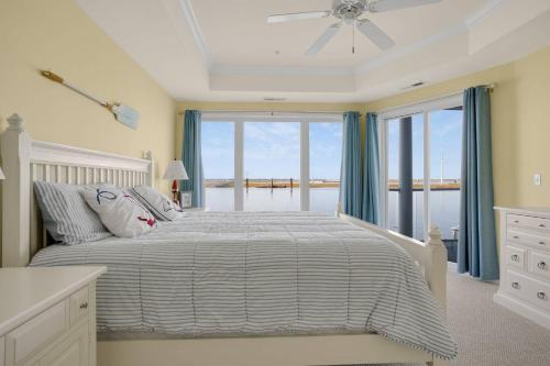 a bedroom with a bed with a view of the ocean at Sunset Bay Villa 119 - Waterfront & shared pool! in Chincoteague