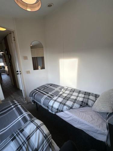 a bedroom with two beds and a mirror at 8 berth Waterside Ingoldmells V8 Santanavan 3 in Skegness