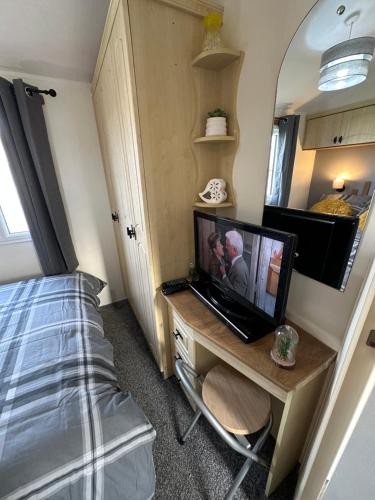 a bedroom with a desk with a laptop and a bed at 8 berth Waterside Ingoldmells V8 Santanavan 3 in Skegness