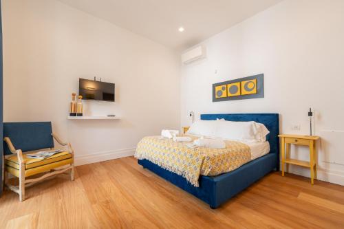 a bedroom with a blue bed and a chair at La SuiteDellAvvocato in Naples