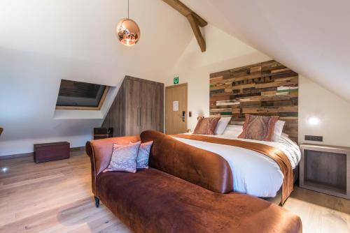 a bedroom with a bed and a couch at Koru Hôtel & Private Wellness in Autre-Église