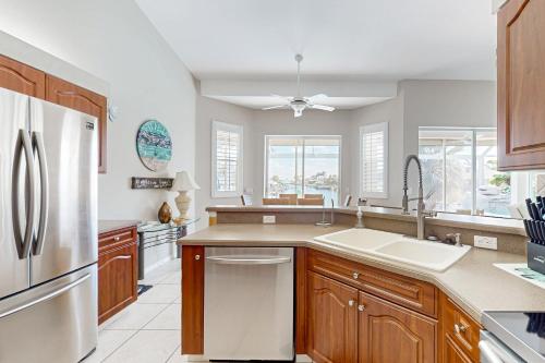 una cocina con fregadero y refrigerador en Villa Kelleigh Anne, en Cabo Coral