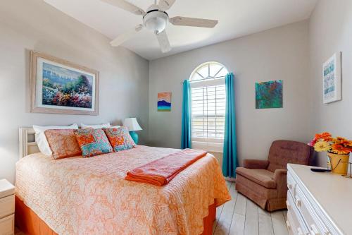 Un dormitorio con una cama y una silla y una ventana. en Villa Kelleigh Anne, en Cabo Coral