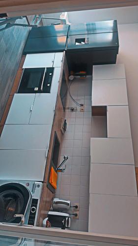 une vue d'une cuisine avec une machine à laver dans l'établissement Appartement avec balcon a 2 pas la gare, à Villefranche-sur-Saône